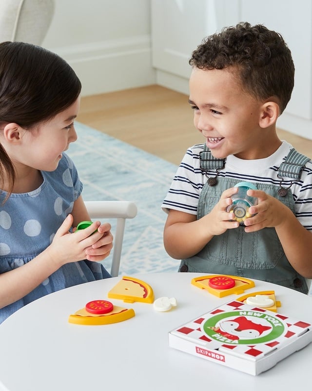 il bambino gioca con frutta e verdura di plastica a fette con il velcro,  cuoce il