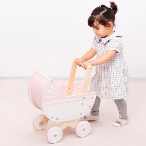 New Classic Toys Dřevěný kočárek pro panenky s polštářkem a peřinkou – růžový